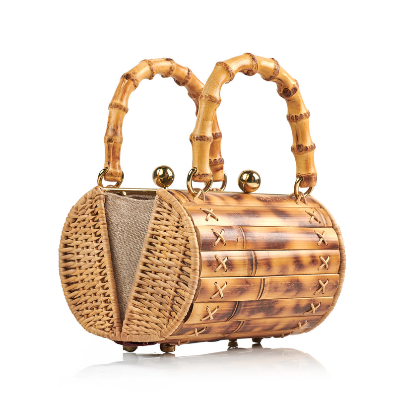 Bolsa estruturada feita em bambu, com alça arredondada em bambu, fecho dourado e costura cruzada lateral.