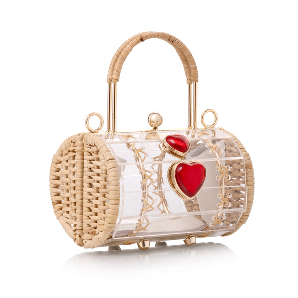 Bolsa artesanal em formato cilíndrico, feita à mão em acrílico transparente com corações vermelhos e estrutura dourada em vime.