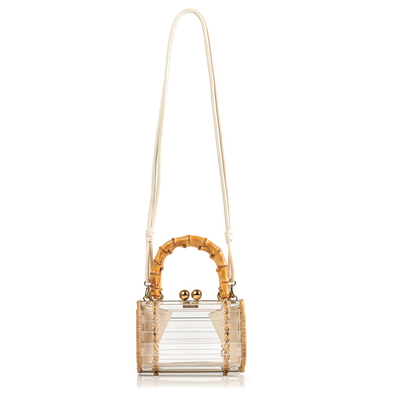 Bolsa box em acrílico transparente com laterais em rattan, detalhe de costura em X dourado, alça rígida em bambu e fecho esférico metálico dourado.