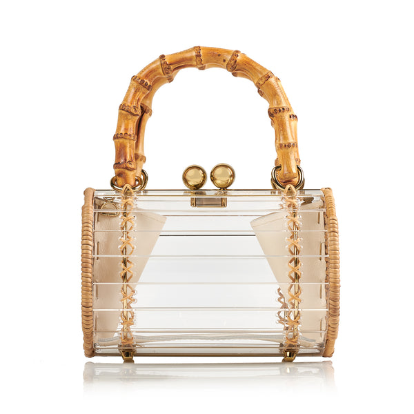 Bolsa box em acrílico transparente com laterais em rattan, detalhe de costura em X dourado, alça rígida em bambu e fecho esférico metálico dourado.
