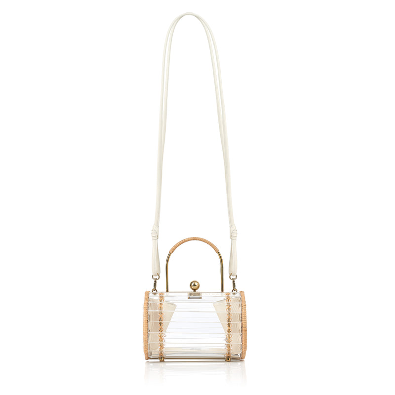 Bolsa box estruturada em acrílico transparente com laterais em rattan, detalhe de costura em X dourado, alça rígida metálica com revestimento em rattan e fecho esférico dourado.