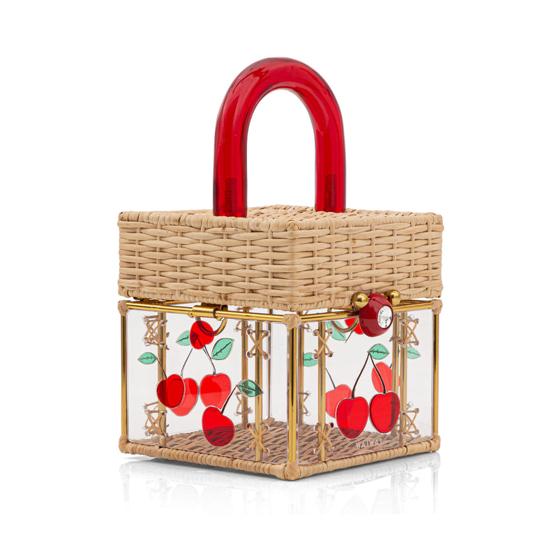 Bolsa box em palha natural com corpo transparente decorado com cerejas em acrílico vermelho. Possui alça estruturada em acrílico vermelho, fechamento frontal com detalhe redondo e ferragens douradas.