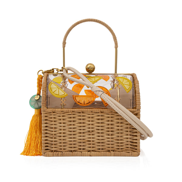 Bolsa box em palha natural com tampa em acrílico verde fosco, ornada com fatias de laranja em relevo, alça rígida, fecho metálico dourado e tassel amarelo com detalhe transparente.