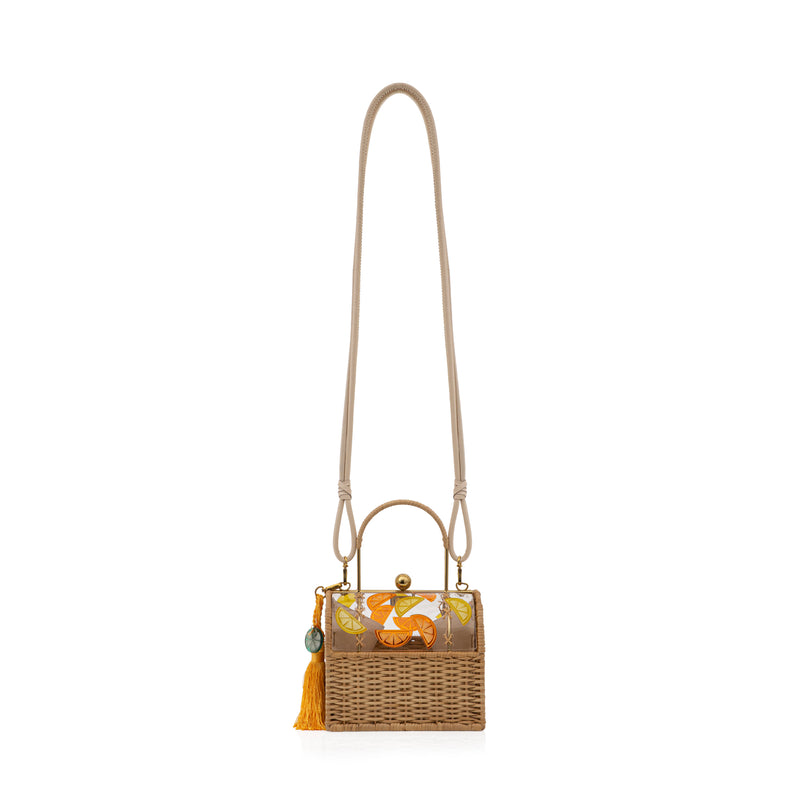 Bolsa box em palha natural com parte superior em acrílico transparente decorado com fatias de frutas cítricas em laranja, amarelo e verde. Possui alça estruturada, fecho dourado e tassel amarelo com detalhe em acrílico verde.