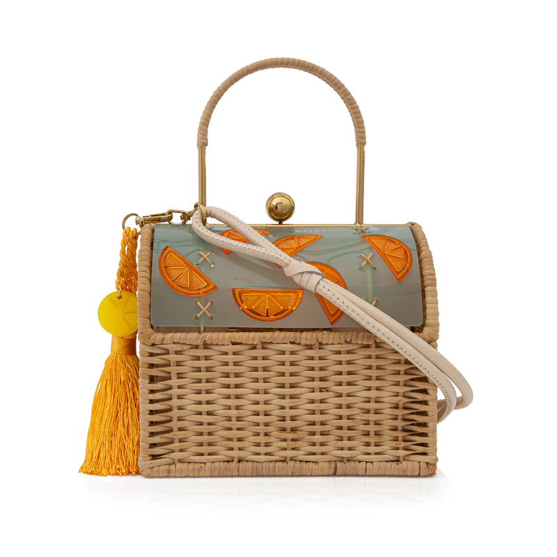Bolsa box em palha natural com parte superior em acrílico fosco esverdeado, decorado com fatias de laranja em relevo. Possui alça estruturada, fecho dourado e tassel amarelo com detalhe em acrílico transparente.