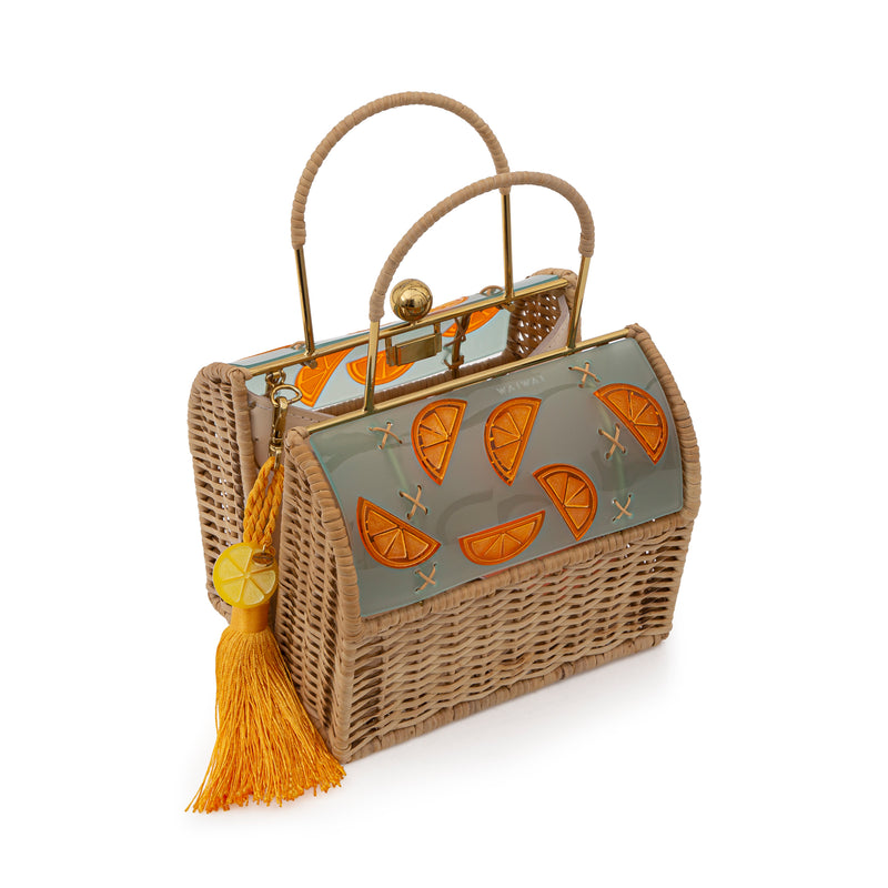Bolsa box em palha natural com parte superior em acrílico fosco esverdeado, decorado com fatias de laranja em relevo. Possui alça estruturada, fecho dourado e tassel amarelo com detalhe em acrílico transparente.