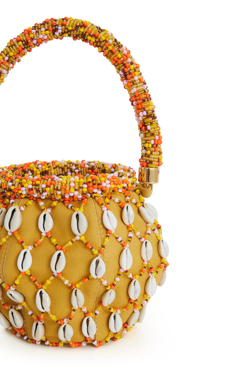 Bolsa bucket amarela bordada com miçangas coloridas em tons de laranja, amarelo e branco, alça estruturada com o mesmo bordado e aplicação de conchas em toda a superfície.
