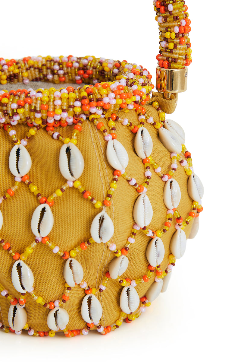 Bolsa bucket amarela bordada com miçangas coloridas em tons de laranja, amarelo e branco, alça estruturada com o mesmo bordado e aplicação de conchas em toda a superfície.