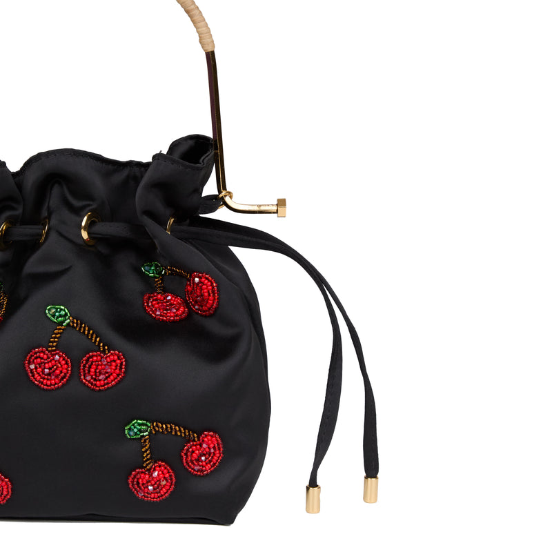 Bolsa bucket em seda preta com bordado de cerejas vermelhas em miçangas, folhas verdes, alça estruturada em metal dourado com detalhe em rattan e fechamento por cordão ajustável.