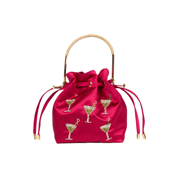 Bolsa bucket em seda rosa vibrante com aplicações bordadas de taças de cocktail decoradas com cristais, alça estruturada em metal dourado com detalhe em rattan e fechamento por cordão ajustável.