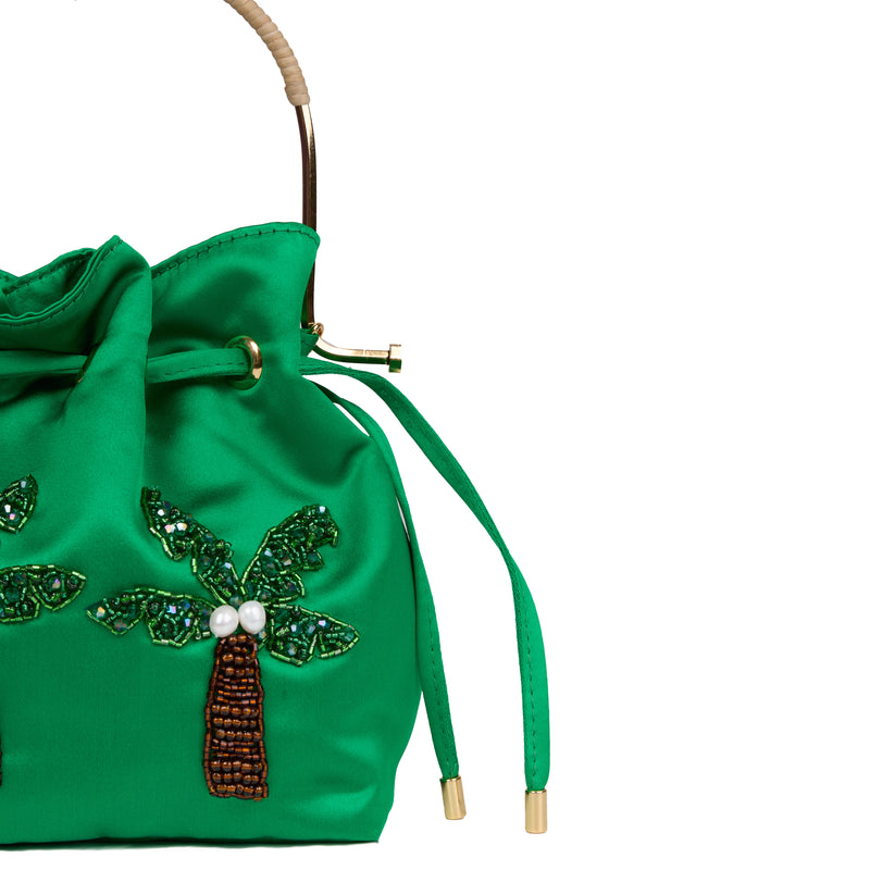 Bolsa artesanal bucket em seda verde, bordada com duas palmeiras de miçangas e pérolas, alça de metal dourado com detalhe em rattan e fechamento em cordão.
