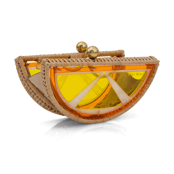 Clutch em formato de meia-lua inspirada em fatia de laranja, feita em rattan e acrílico amarelo translúcido com fecho dourado.