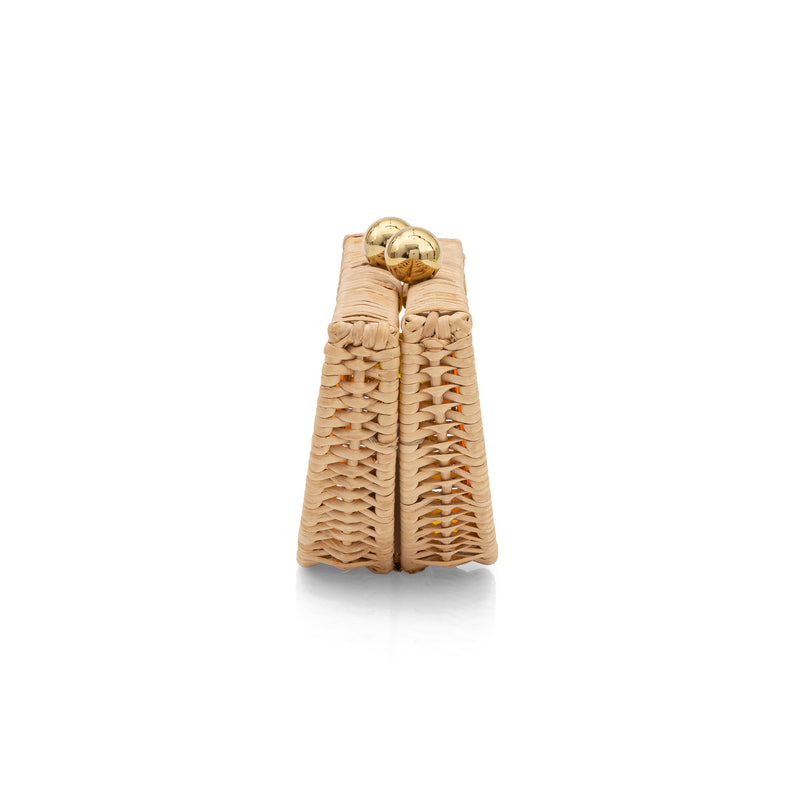 Clutch estruturada em formato meia-lua, inspirada em laranja, confeccionada em rattan e acrílico amarelo translúcido com fecho dourado.