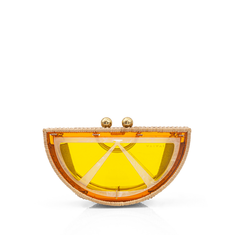 Bolsa clutch pequena em formato de meia-lua, inspirada em uma fatia de laranja, estruturada em rattan e acrílico amarelo translúcido com fecho dourado.
