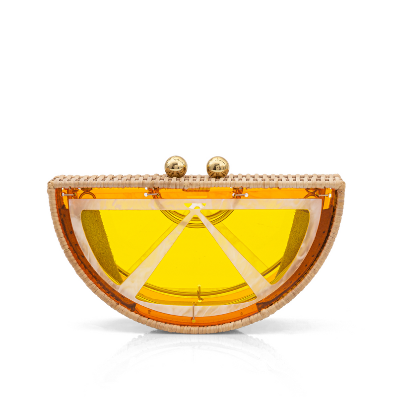 Bolsa clutch em formato de meia-lua, inspirada em uma fatia de laranja, estruturada em rattan e acrílico amarelo translúcido com fecho dourado.