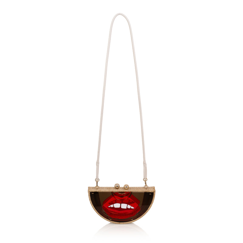 Clutch em formato meia-lua com estrutura em rattan e acrílico marrom translúcido, estampa frontal de boca vermelha estilizada com dentes à mostra e fecho metálico dourado no topo.