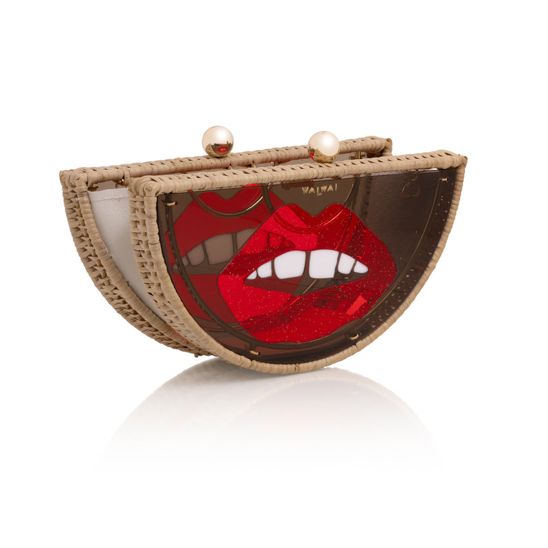 Clutch em formato meia-lua com estrutura em rattan e acrílico marrom translúcido, estampa frontal de boca vermelha estilizada com dentes à mostra e fecho metálico dourado no topo.
