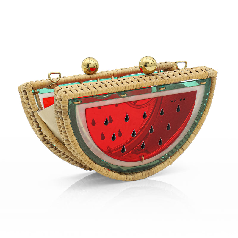 Clutch menor em formato meia-lua, com estrutura em rattan e acrílico vermelho translúcido, estampa divertida de melancia com sementes pretas e fecho metálico dourado no topo.