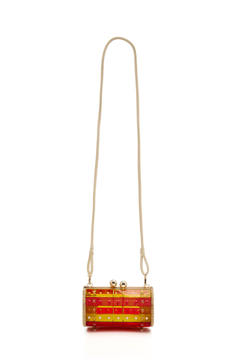 Clutch em rattan natural com corpo em acrílico translúcido listrado nas cores vermelho e amarelo, adornada com cristais e fecho metálico dourado.