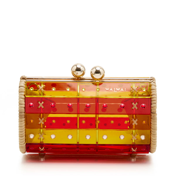 Clutch estruturada em rattan com corpo em acrílico translúcido listrado em tons de vermelho e amarelo, aplicação de cristais e fecho metálico dourado no topo.