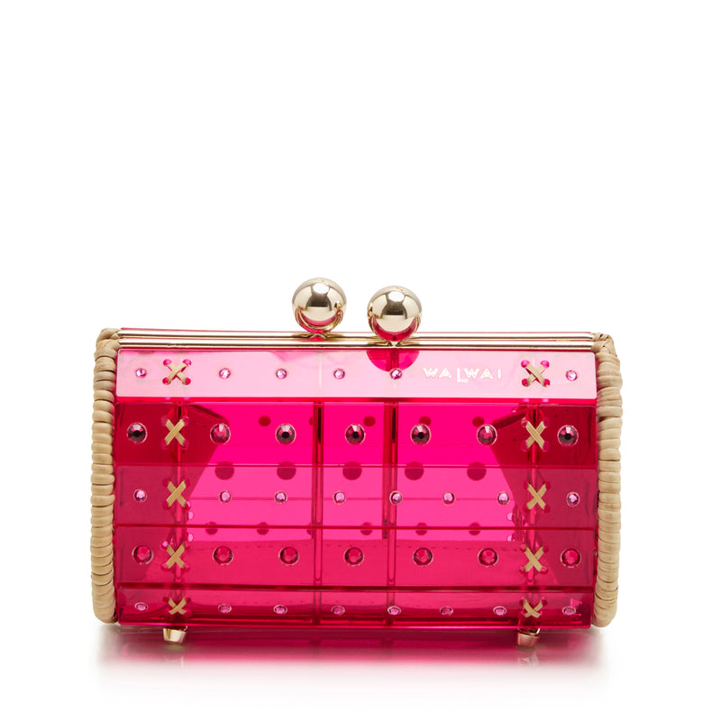 Clutch estruturada em rattan com corpo em acrílico rosa translúcido, aplicação de cristais circulares e fecho metálico dourado no topo.