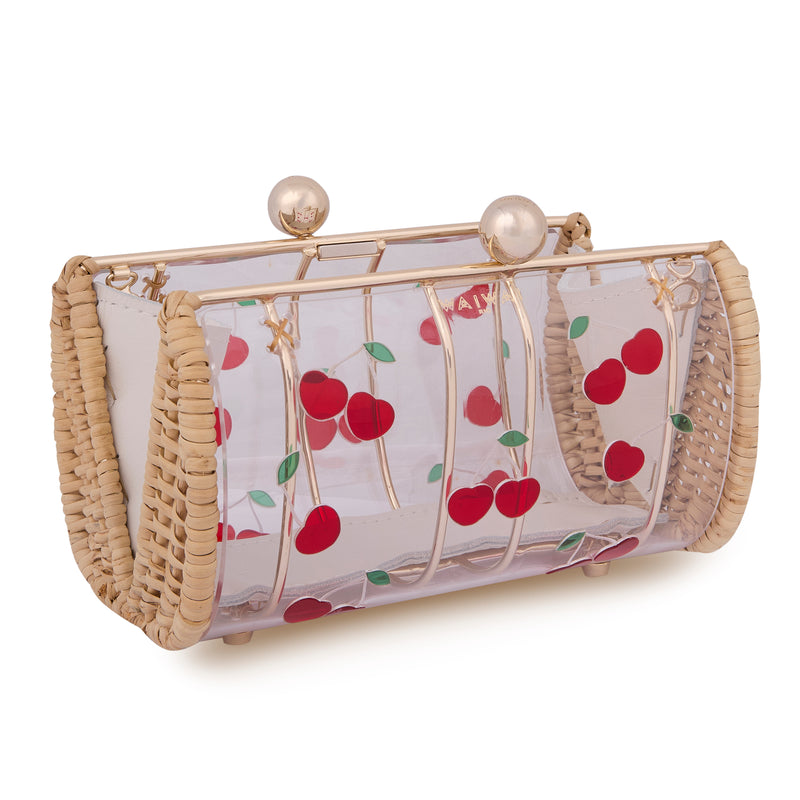 Bolsa clutch artesanal em rattan natural, corpo em acrílico transparente, cerejas vermelhas estampadas e fecho metálico dourado.