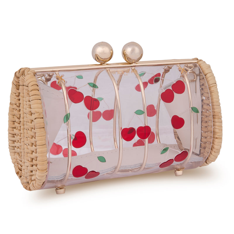 Clutch autoral em rattan e acrílico transparente, frente decorada com cerejas vermelhas com folhas verdes e fecho dourado superior.