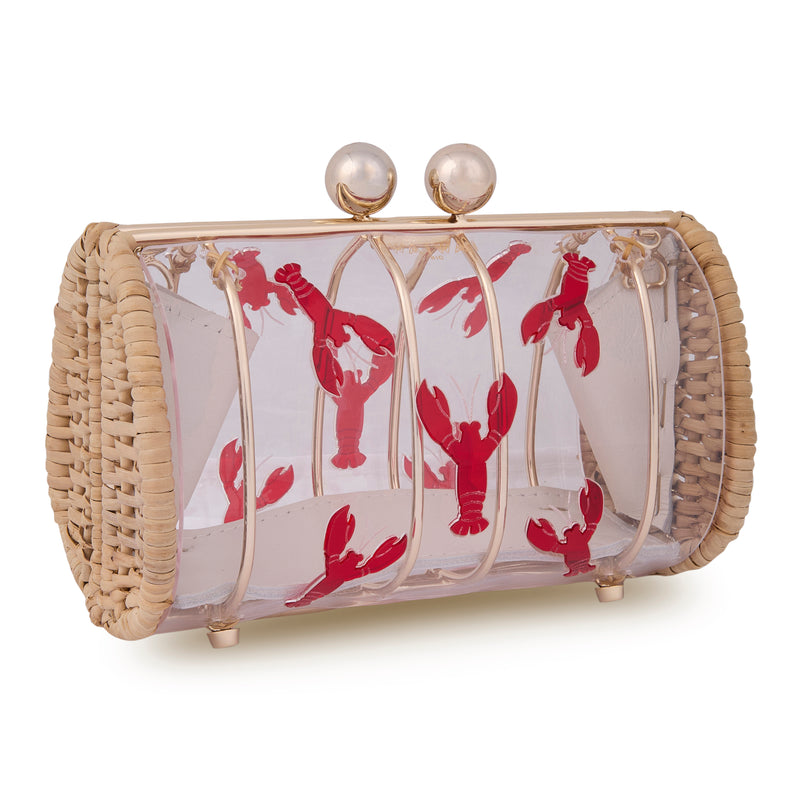 Clutch autoral em rattan e acrílico transparente, frente ilustrada com lagostas vermelhas e fecho dourado superior.