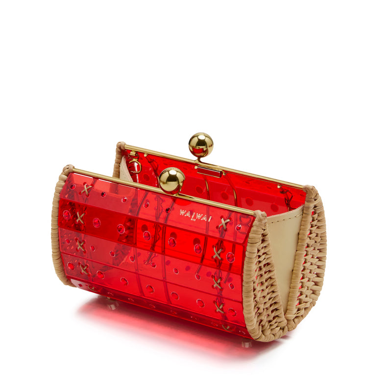 Clutch estruturada em rattan com corpo em acrílico vermelho translúcido, aplicação de cristais circulares e fecho metálico dourado no topo.