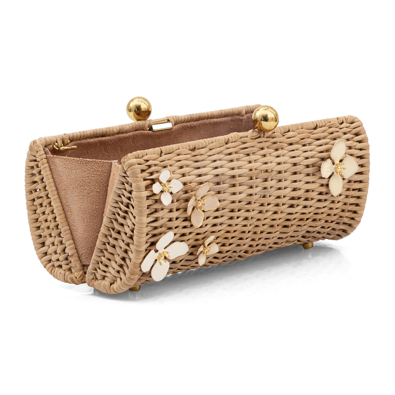Clutch retangular estruturada em rattan natural com flores esmaltadas em marfim e pés metálicos dourados.
