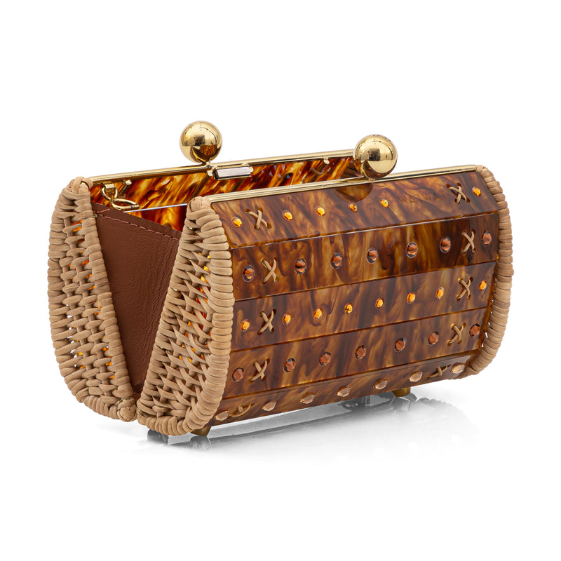 Clutch pequena estruturada em acrílico tartaruga com detalhes de strass, laterais em palha natural e fecho esférico dourado.