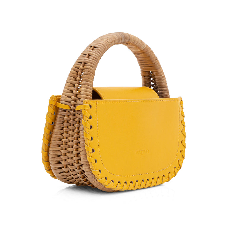 Bolsa de mão em couro amarelo estruturada, alça rígida em bambu natural e bordas com detalhes trançados. Sofisticada e minimalista.