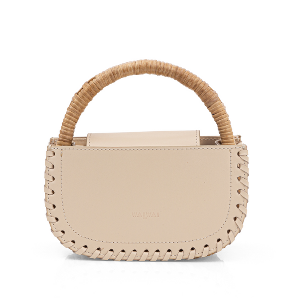 Bolsa de mão estruturada em couro bege claro, com alça em bambu natural e detalhes trançados nas bordas. Design sofisticado e minimalista, ideal para composições elegantes.