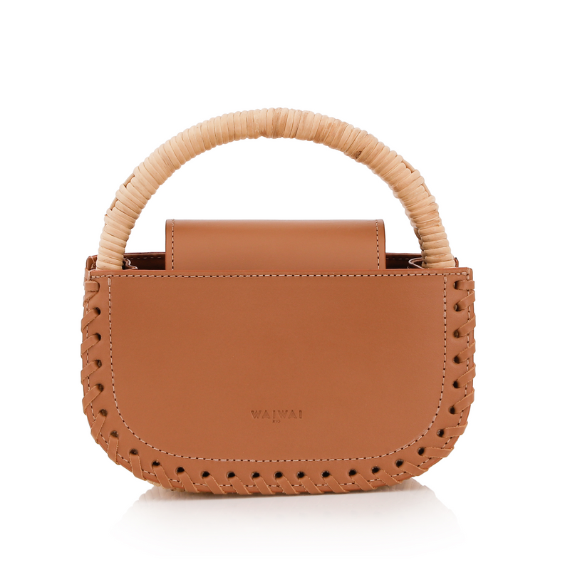 Bolsa de couro marrom claro com detalhe de costura trançada nas laterais e alça estruturada revestida em vime natural.