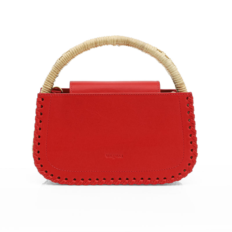 Bolsa estruturada em couro vermelho com detalhe de costura nas bordas e alça em rattan trançado.