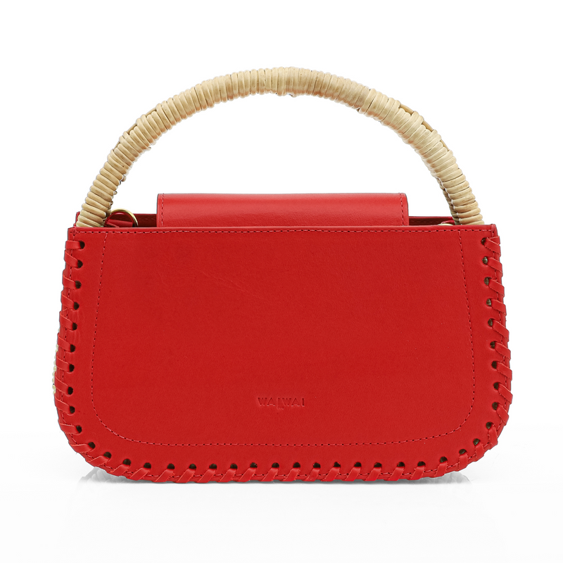 Bolsa estruturada em couro vermelho com detalhe de costura nas bordas e alça em rattan trançado.