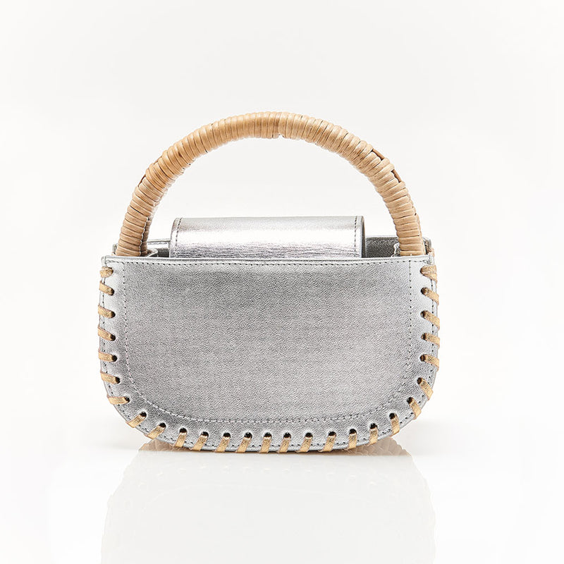Bolsa em couro metálico prateado com costura nas bordas e alça estruturada em rattan. Estilo contemporâneo elegante.