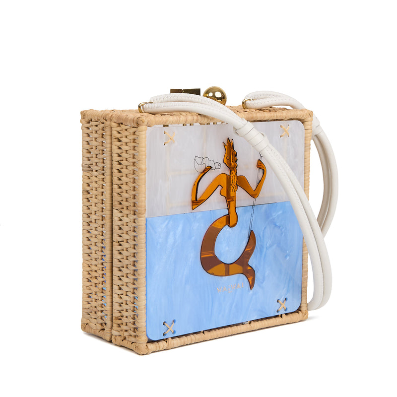 Bolsa quadrada estruturada em rattan com painel em acrílico marmorizado, estampa central de sereia dourada sobre fundo azul, fecho metálico dourado e alça longa em couro branco.