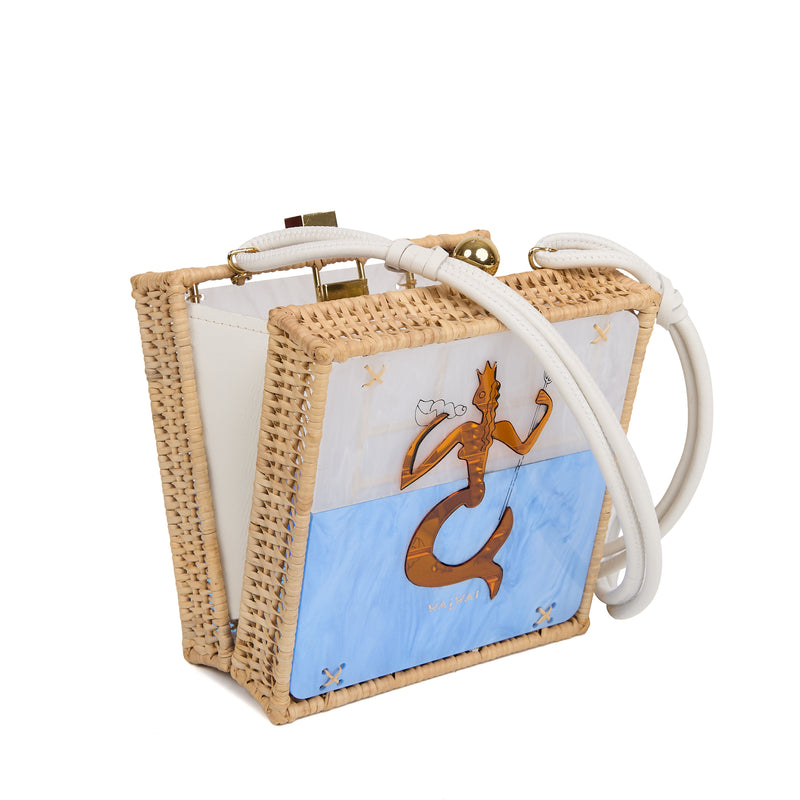 Bolsa quadrada estruturada em rattan com painel em acrílico marmorizado, estampa central de sereia dourada sobre fundo azul, fecho metálico dourado e alça longa em couro branco.