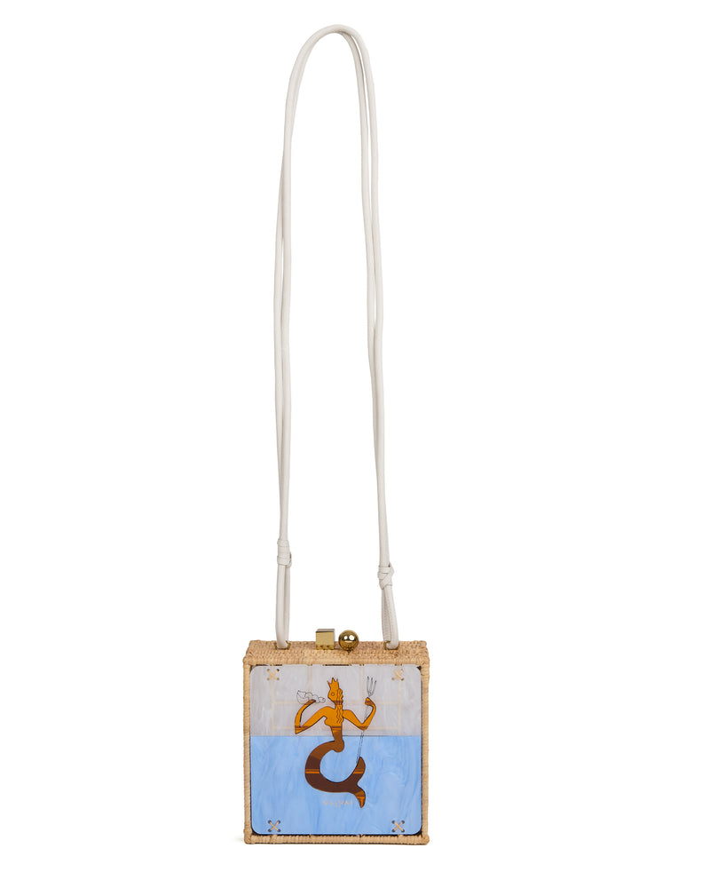 Bolsa quadrada estruturada em rattan com painel em acrílico marmorizado, estampa central de sereia dourada sobre fundo azul, fecho metálico dourado e alça longa em couro branco.