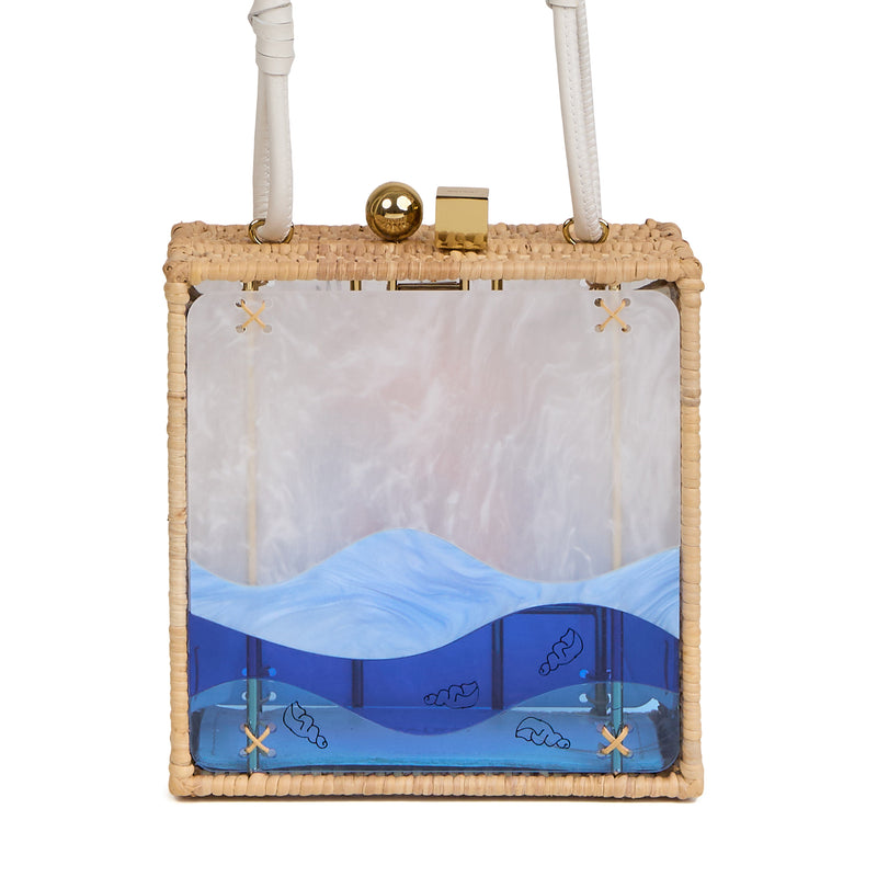Bolsa quadrada estruturada em rattan com painel em acrílico marmorizado, estampa central de sereia dourada sobre fundo azul, fecho metálico dourado e alça longa em couro branco.