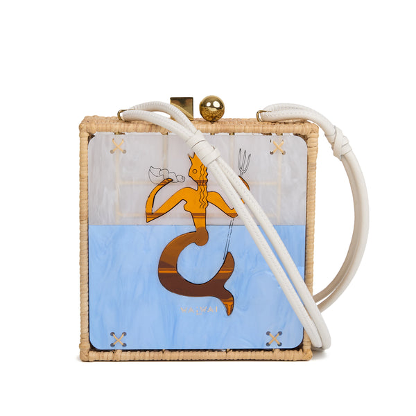 Bolsa quadrada estruturada em rattan com painel em acrílico marmorizado, estampa central de sereia dourada sobre fundo azul, fecho metálico dourado e alça longa em couro branco.