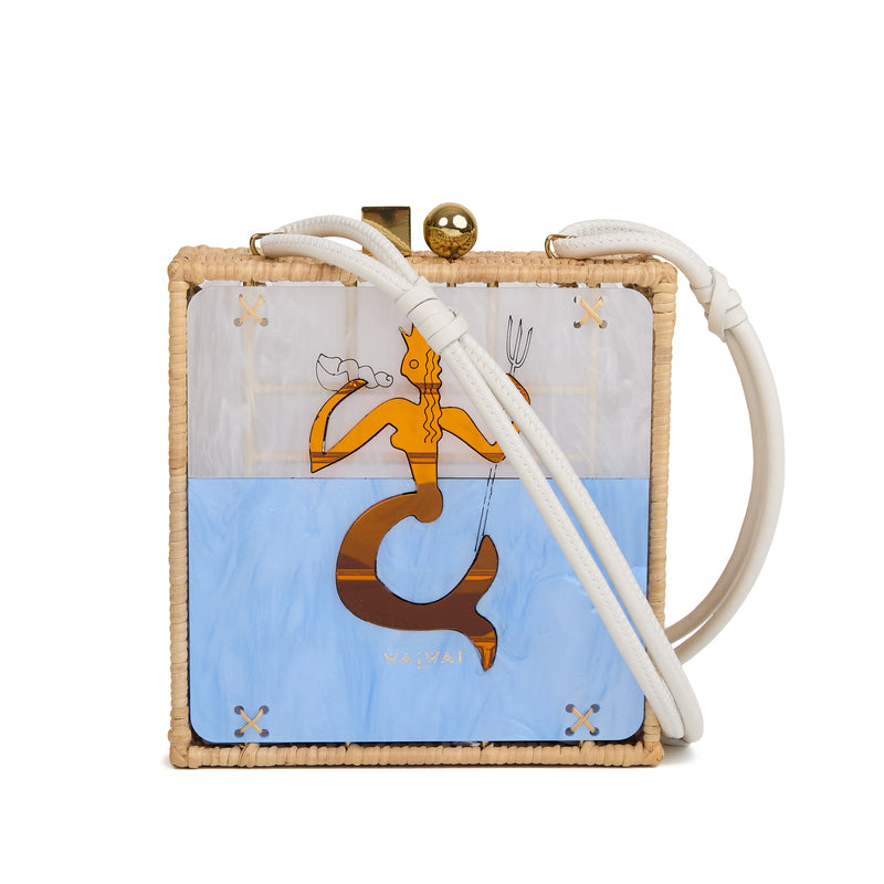 Bolsa quadrada estruturada em rattan com painel em acrílico marmorizado, estampa central de sereia dourada sobre fundo azul, fecho metálico dourado e alça longa em couro branco.