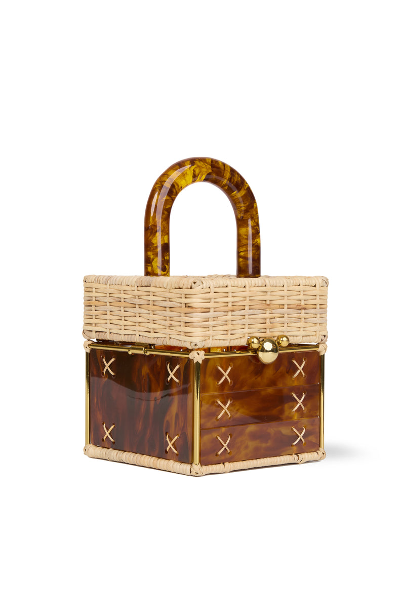 Bolsa pequena estruturada em rattan natural com base em acrílico marrom marmorizado, detalhe de costura em X e alça rígida em acrílico marmorizado marrom.