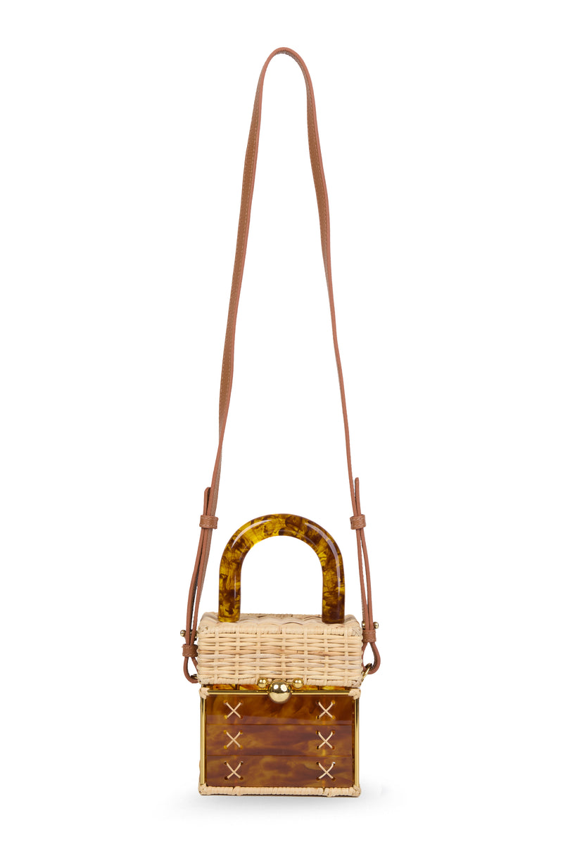 Bolsa pequena estruturada em rattan natural com base em acrílico marrom marmorizado, detalhe de costura em X e alça rígida em acrílico marmorizado marrom.