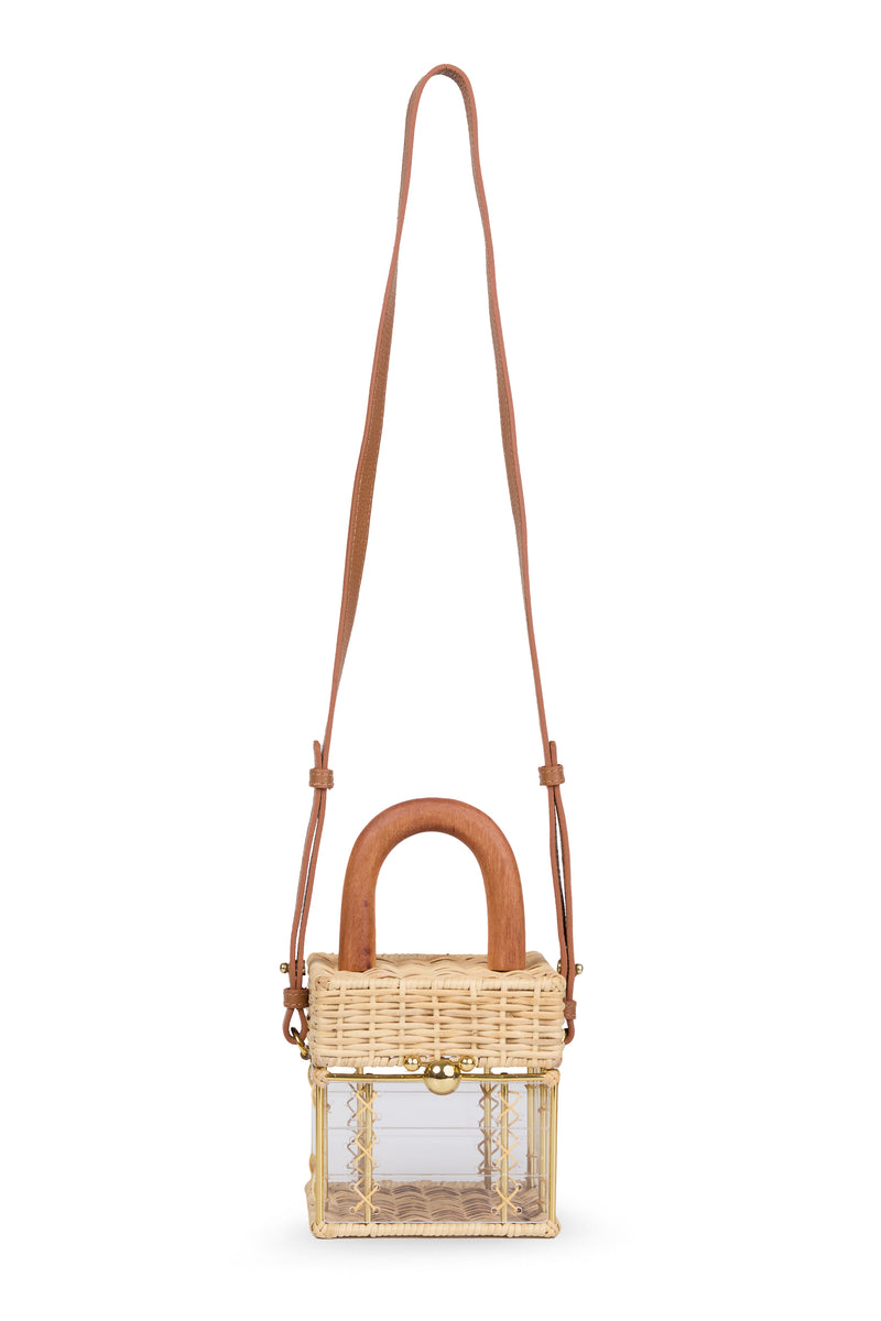Bolsa pequena estruturada em rattan natural com base em acrílico transparente, detalhe de costura em X e alça rígida em madeira.