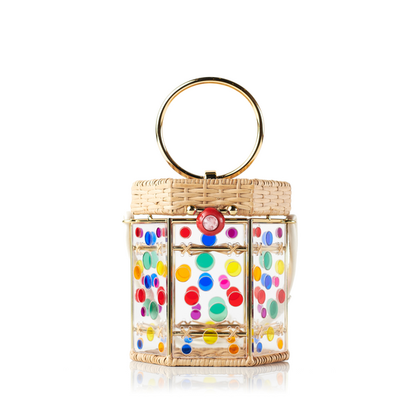 Bolsa estruturada em rattan com corpo em acrílico transparente, aplicações de círculos coloridos, fecho esférico vermelho e alça metálica circular.