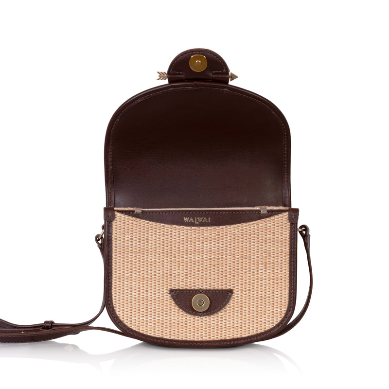 Bolsa Waiwai em rattan natural com acabamento em couro marrom e fecho redondo central em resina marrom com detalhe dourado.