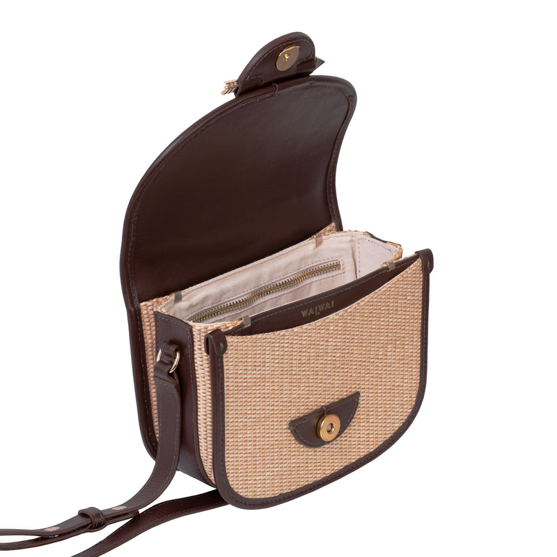 Bolsa Waiwai em rattan natural com acabamento em couro marrom e fecho redondo central em resina marrom com detalhe dourado.