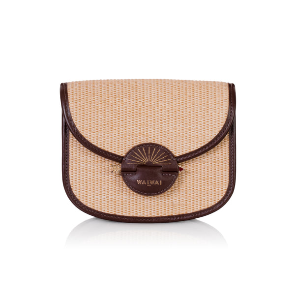 Bolsa Waiwai em rattan natural com acabamento em couro marrom e fecho redondo central em resina marrom com detalhe dourado.